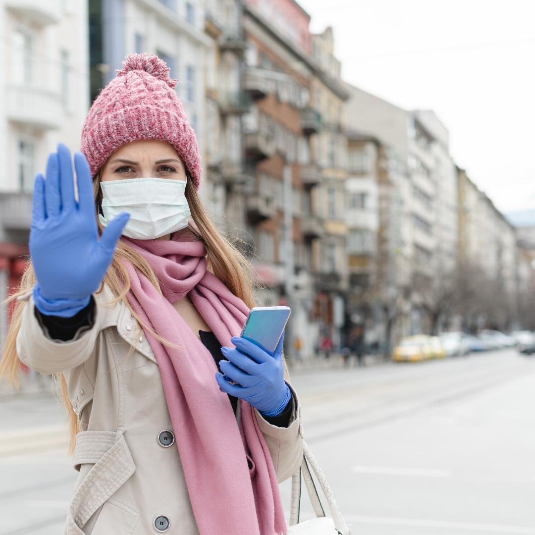 Masked woman holding out hand to stop